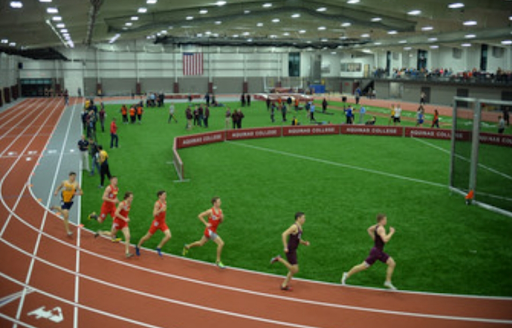 Alkinsis indoor track and field. Athletes run on the track in the foreground.