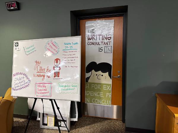 Image of the exterior of the Writing Center. Sign reading: "Aquinas Writing Center, Why Write Alone?"