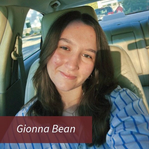Selfie of a girl with long, dark hair, in a car. Text reading: Gionna Bean