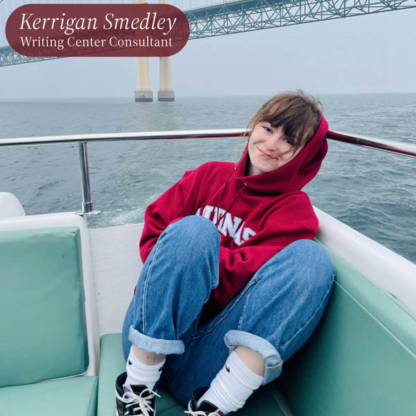 Picture of a girl with dark bangs, in an Aquinas College sweatshirt and blue jeans, in a boat under the Mackinac Bridge. Text reading: Kerrigan Smedley, Writing Center Consultant.