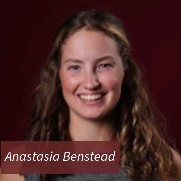 Photo of a girl with long, curly hair, in front of a maroon background. Text Reading: Anastasia Benstead.