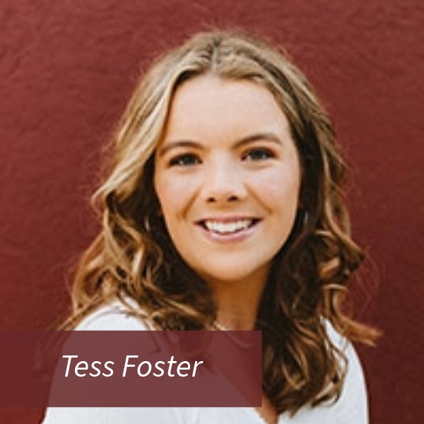 Headshot of a girl with shoulder length hair, in front of a red wall. Text reading: Tess Foster, Writing Center Consultant, Magna Verba Proofreader.