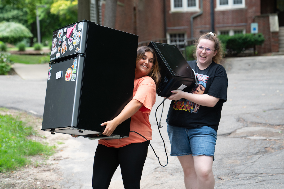 Students carrying items outside for their dorms