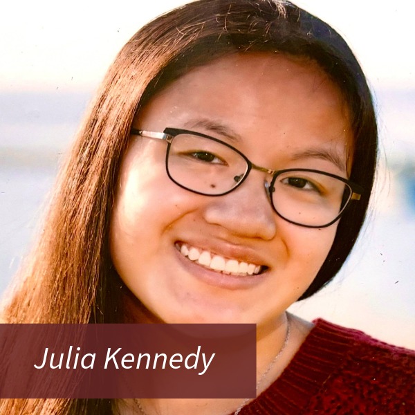 Headshot of a girl with long dark hair and glasses in a red sweater. Text reading: Julia Kennedy, Writing Center Consultant.