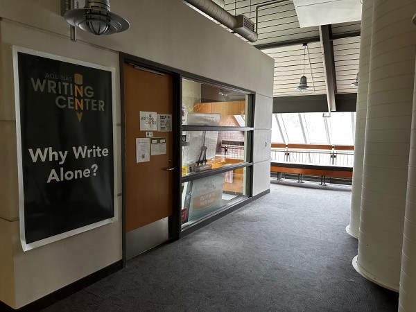 Image of the exterior of the Writing Center. Sign reading: "Aquinas Writing Center, Why Write Alone?"