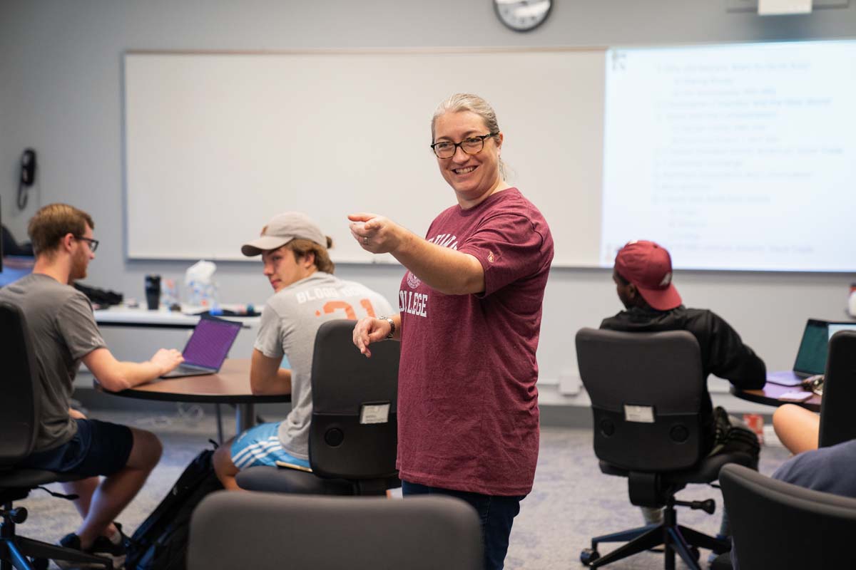 Professor Bethany Kilcrease pointing and smiling in class