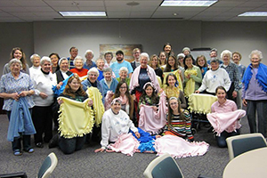 Students holding handmade blankets