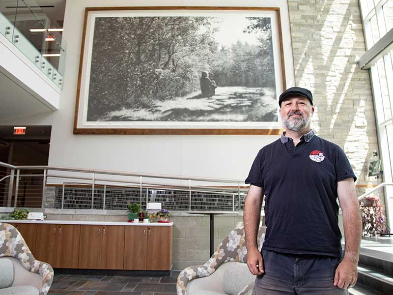 Chris LaPorte in Albertus Magnus Hall of Science with his artwork.