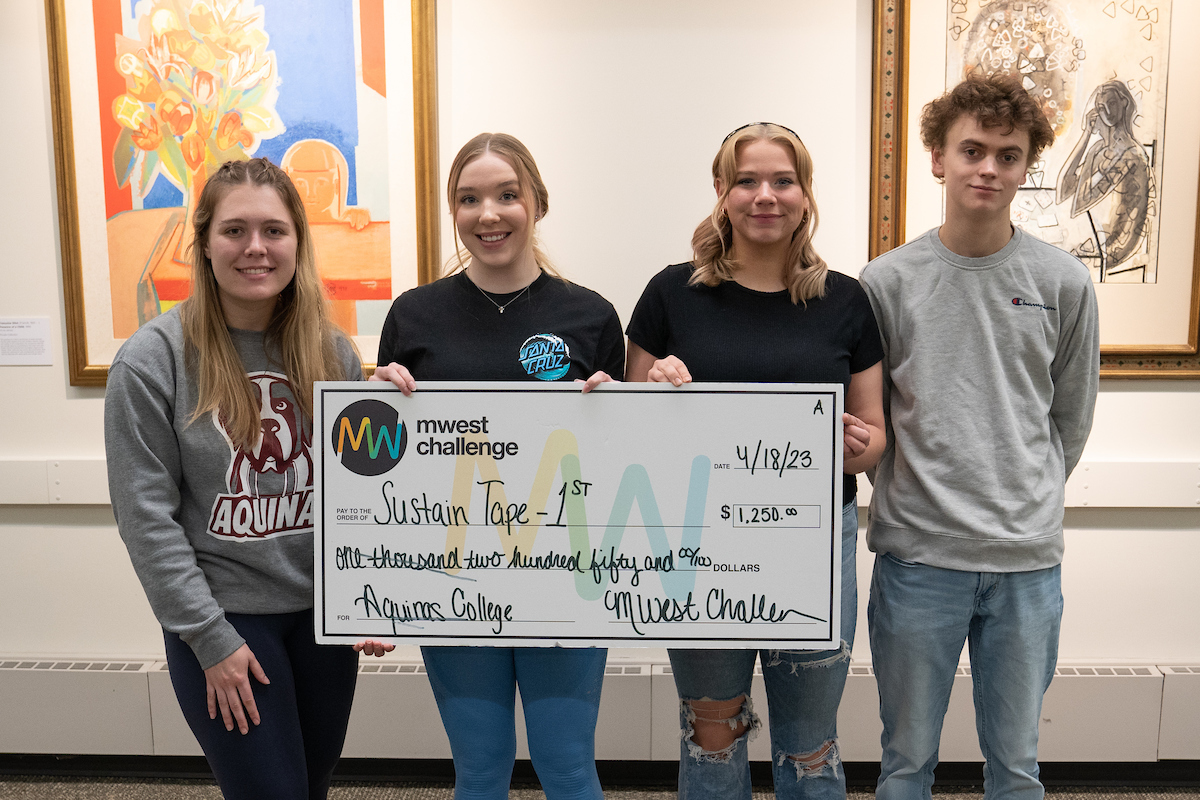 Four students holding an oversized check for SustainTape