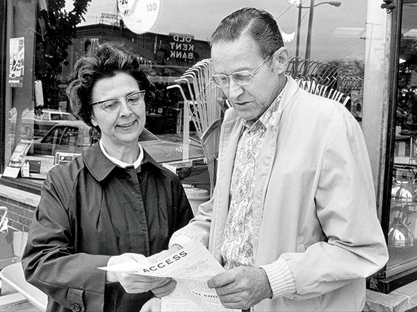 From 1973-1976, Sister Aquinas worked as liaison between Aquinas College and businesses in nearby Eastown. Here she looks at a copy of Eastown Access, the local newsletter, with Jim Geib, owner of Hammer & Cortenhof Hardware.