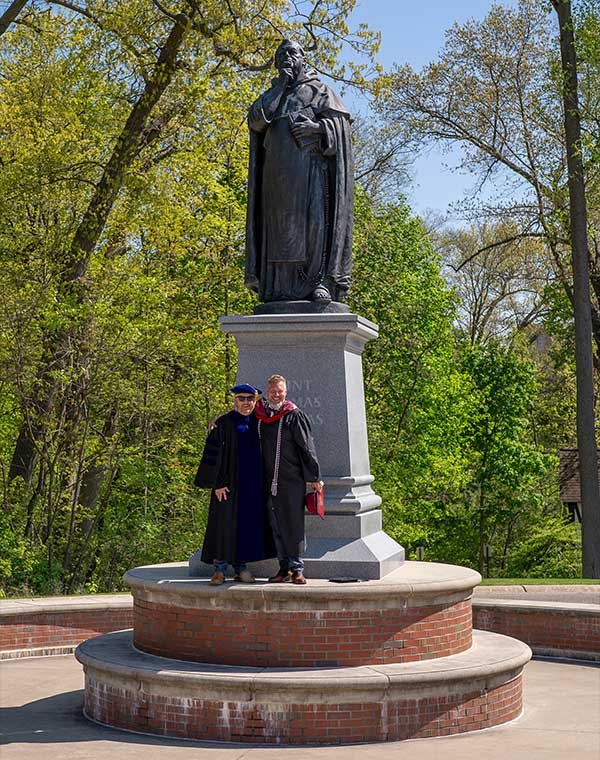 Theology professor and graduate at St. Thomas Aquinas statue